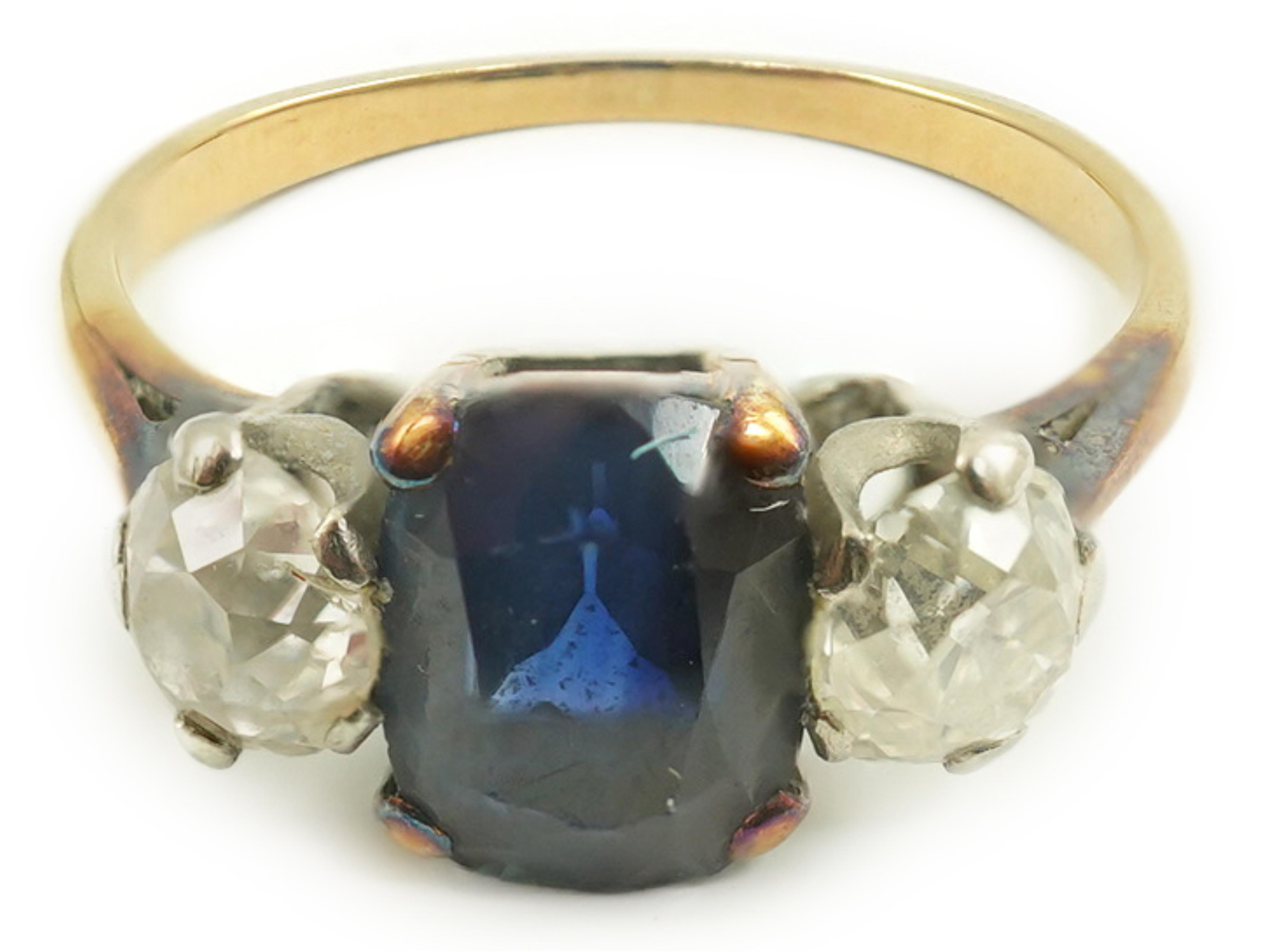 A gold, single stone oval sapphire and two stone round cut diamond set ring